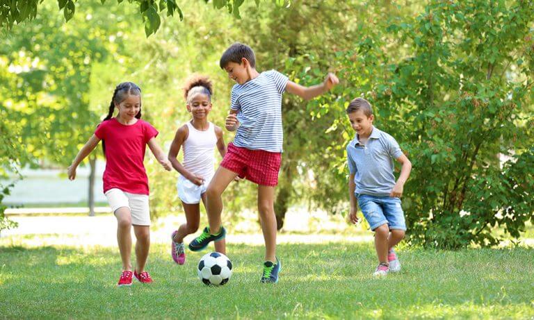 4 Kinder spielen Fußball im Grünen- Käserei Woerle