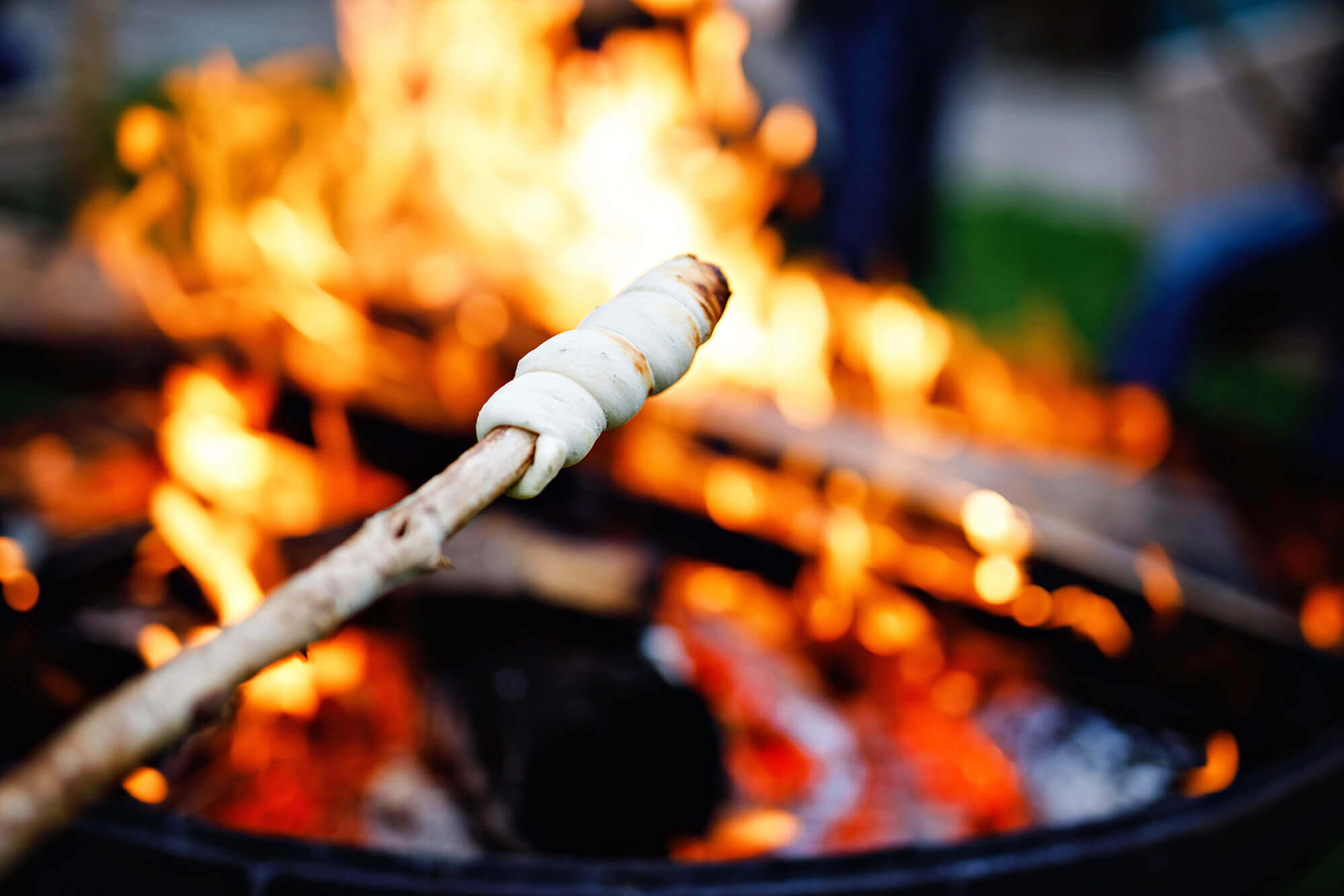 Lagerfeuer mit Essen am Stecken