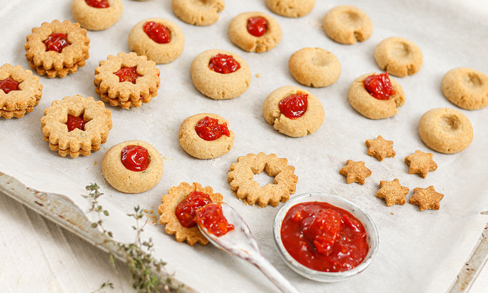 Kekse mit Tomatenmarmelade liegend auf Backblech